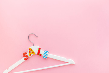 White hangers with sale text on pink background
