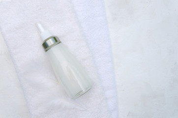 Fototapeta premium Clean white towels glass bottle of softener and feathers on it.Empty space for text