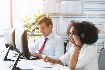 African american woman call center worker accompanied by her team. Smiling customer support...