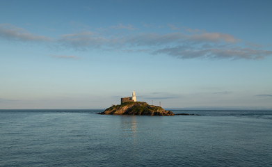 Fototapeta premium Mumbles Lighthouse island The iconic landmark that is Mumbles Lighthouse on the Gower peninsula in Swansea, South Wales, UK.