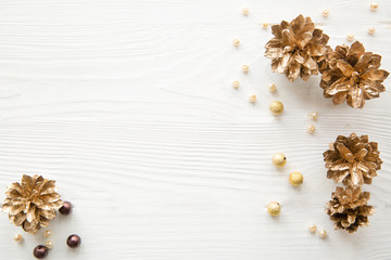 Golden cones and beads decoration Christmas backgorund. Space for text on white table. Winter holiday theme. 