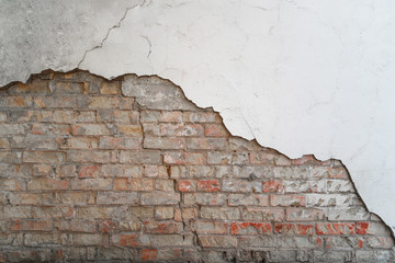Old wall of bricks with chapped plasterwork. 