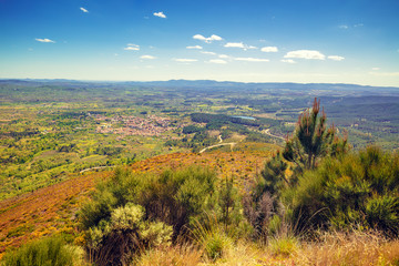 Fototapeta premium Panoramic landscape, view of valley, village in valley, mountains and fiels. Mountain landscape in early spring. Valverde del Fresno, Cáceres, Spain.