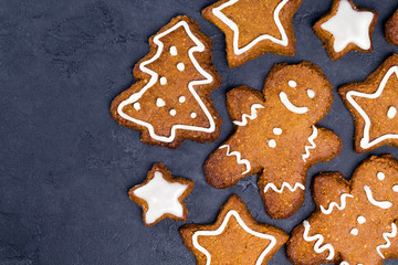 Christmas cookies - star, tree shapes, gingerbread man with white glaze on gray concrete background. Recipe, invitation concept. Top view, flat lay, close-up, copy space, layout design