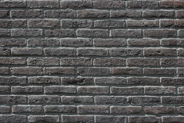 Close up of dark gray brick wall background texture with slightly purplish and earth tones colors details