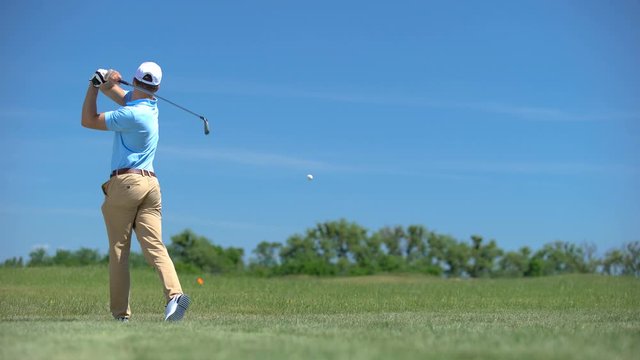 Young male golf player hitting ball in swing position bad result, sport training