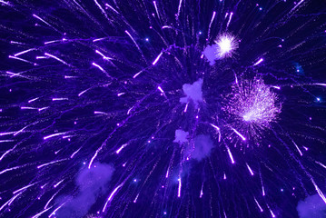 Purple fireworks in the night sky. Violet festive firecracker. Beautiful background