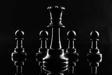 Chess figures on dark black background close up