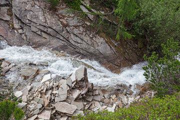Panoramic view of the rushing waters of a stream in the Swiss Alps.