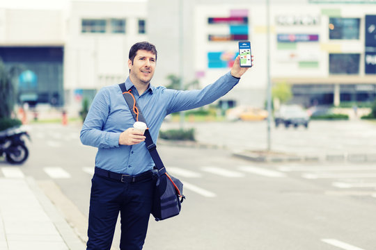 Man Passenger Using Mobile Taxi App Waiting Cab Or Ride Share With Hand Up 