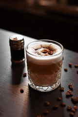 Coffee with milk froth stands on a wooden stand in a coffee shop