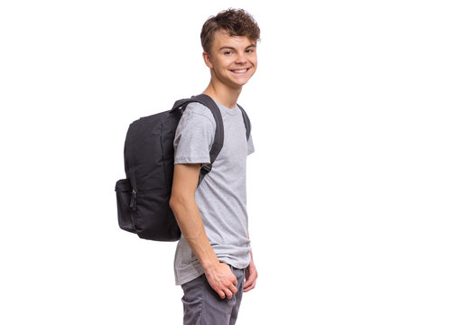 Student teen boy with backpack looking at camera. Portrait of cute smiling schoolboy with hands in pockets, isolated on white background. Happy child Back to school.
