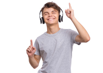 Happy teen boy with headphones, isolated on white background. Cheerful child listening to music,...