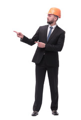 in full growth. serious businesswoman in helmet pointing somewhere to the side