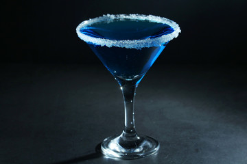 A glass with blue martini cocktail	
