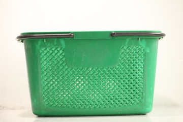 Green plastic shopping basket with black handles.