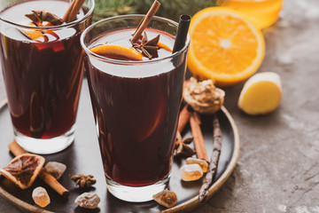 Hot mulled wine with spices, apple and orange on chrictmas background. Copy space.
