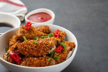 Chicken nuggets with sauce and pepper on a dark background. Copy space.