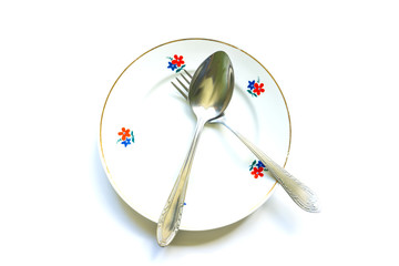 fork and spoon on an empty clean plate