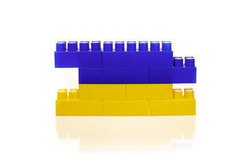 Flag of the Ukraine from a multi-colored children's plastic building kit on a white background
