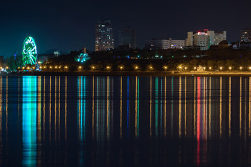 Fototapeta na wymiar Night View of the city of Khabarovsk from the Amur river. Blue night sky. The night city is brightly lit with lanterns. The level of the Amur river at around 159 centimeters.