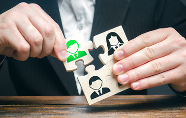 A businessman collects puzzles symbolizing a team of employees. The appointment of the head....