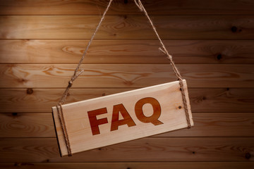 Wooden signboard with the words FAQ on a rough rope on a beautiful wooden background