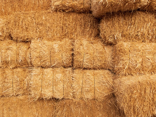 Stacks of dry straw. Piled straw haystacks. Natural dry straw texture background