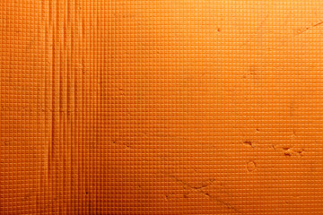 Orange texture consisting of a pattern of small squares, with characteristic folds and small scuffs