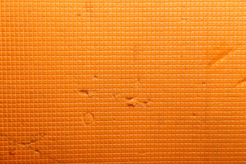 Orange texture consisting of a pattern of small squares, with characteristic folds and small scuffs