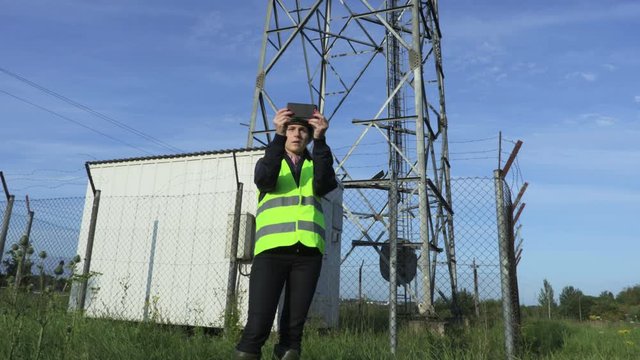 Woman engineer taking pictures of  Wireless communication tower with smartphone .Communication and connection concept