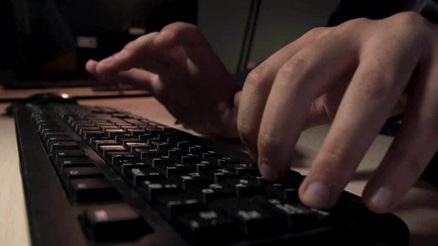Close up for man hands typing something on computer keyboard, office work concept. Stock footage. Male fingers pressing the black buttons of his computer, time lapse.