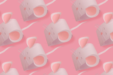 The mouse is made of white paper on a pink background.