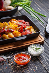 Potato baked with sausages along with white and red sauce