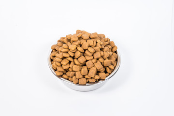 Full Cup with a slide of dry pet food isolated on white background. Metal bowl for cat or dog. The concept of proper nutrition, abundance of food, the harm of overeating, health hazards. Copy space