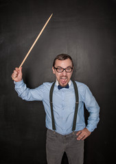 Angry screaming teacher with pointer on blackboard chalkboard