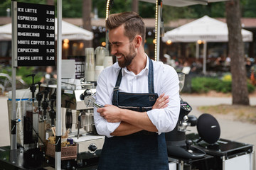 Handsome barista man during work in his street coffee shop