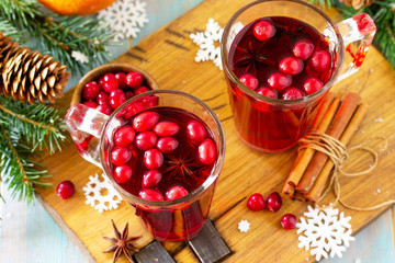 Christmas, Thanksgiving drinks close-up. Hot winter drink with cranberries and cinnamon on wooden table.