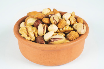 bowl with mixed nuts on white background. Healthy food and snack. Walnut, pecan, almonds, hazelnuts and cashews