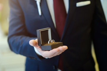 groom holding box with wedding ring