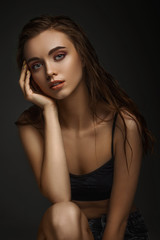 Fototapeta premium portrait of gorgeous sexy woman with perfect skin and long wet hair on dark background. girl looking at camera