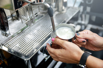 Barista is preparing coffee with milk