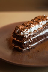 Tiramisu cake on brown background. Minimal modern dessert concept