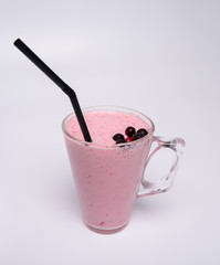 Glass of pink strawberry milkshake or cocktail isolated on white background.