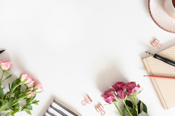 Feminine border frame made of flowers, mug of coffee and stationery on white background