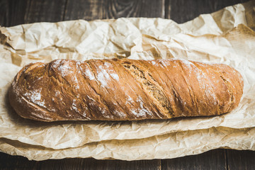 Freshly baked rustic bread on the rustic background. Selective focus. Shallow depth of field.