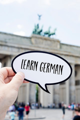text learn german in front of the Brandenburg Gate