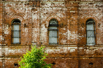 Fototapeta na wymiar Red brick wall with windows. Old ruined church. Restoration of the temple, Russia