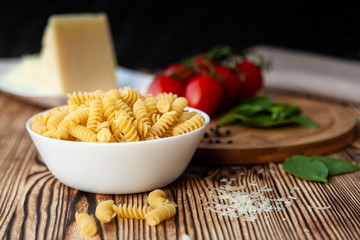 Ingredients for preparation of pasta. Grated cheese, tomatoes, olive oil, garlic. Italian food.