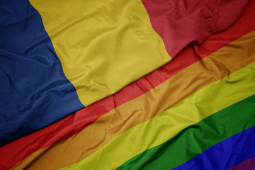 waving colorful gay rainbow flag and national flag of romania.